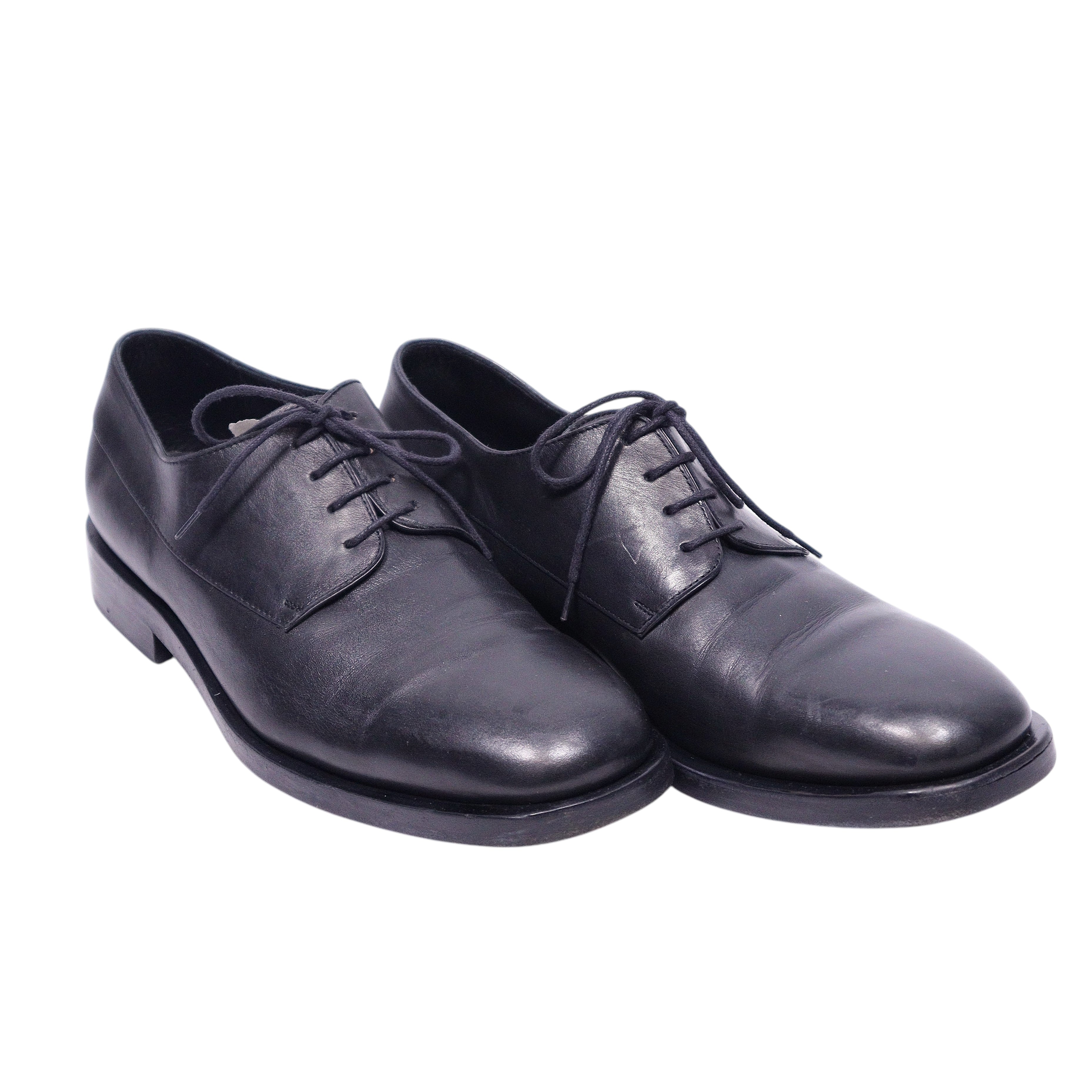 A pair of Christian Dior black leather dress shoes with lace-up closure.Christian Dior black leather lace-up derby shoes with a smooth, slightly glossy finish, round toe and low heel. Minimalist dress shoes with open lacing and a sturdy sole; vintage, high-end, rare.