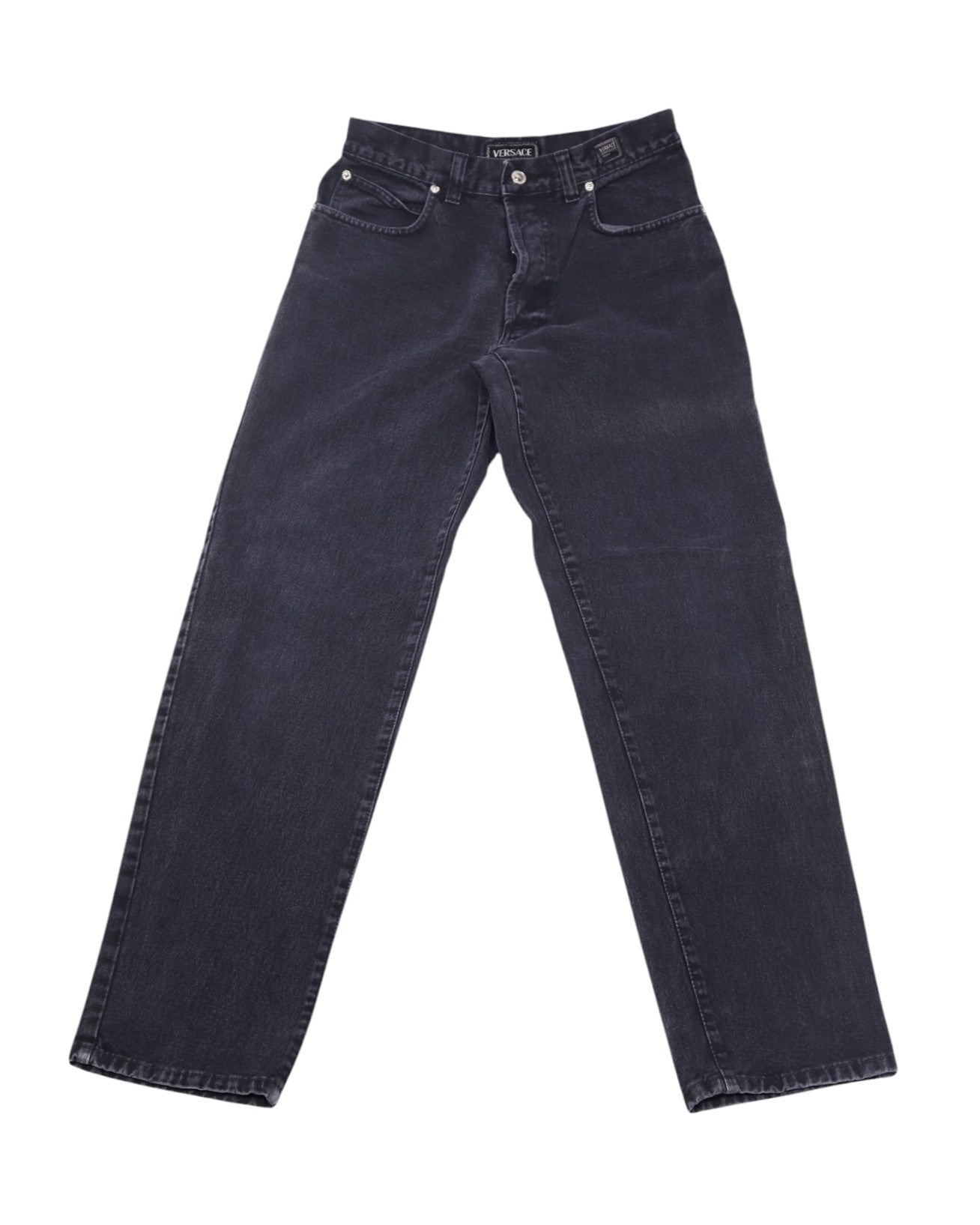 Vintage Gianni Versace Jeans Couture dark charcoal/black denim jeans/jean trousers with a gently faded wash; mid-rise straight-leg, classic five-pocket style with belt loops, button front and clean hems. Heritage luxury, rare and unique piece laid flat on white.