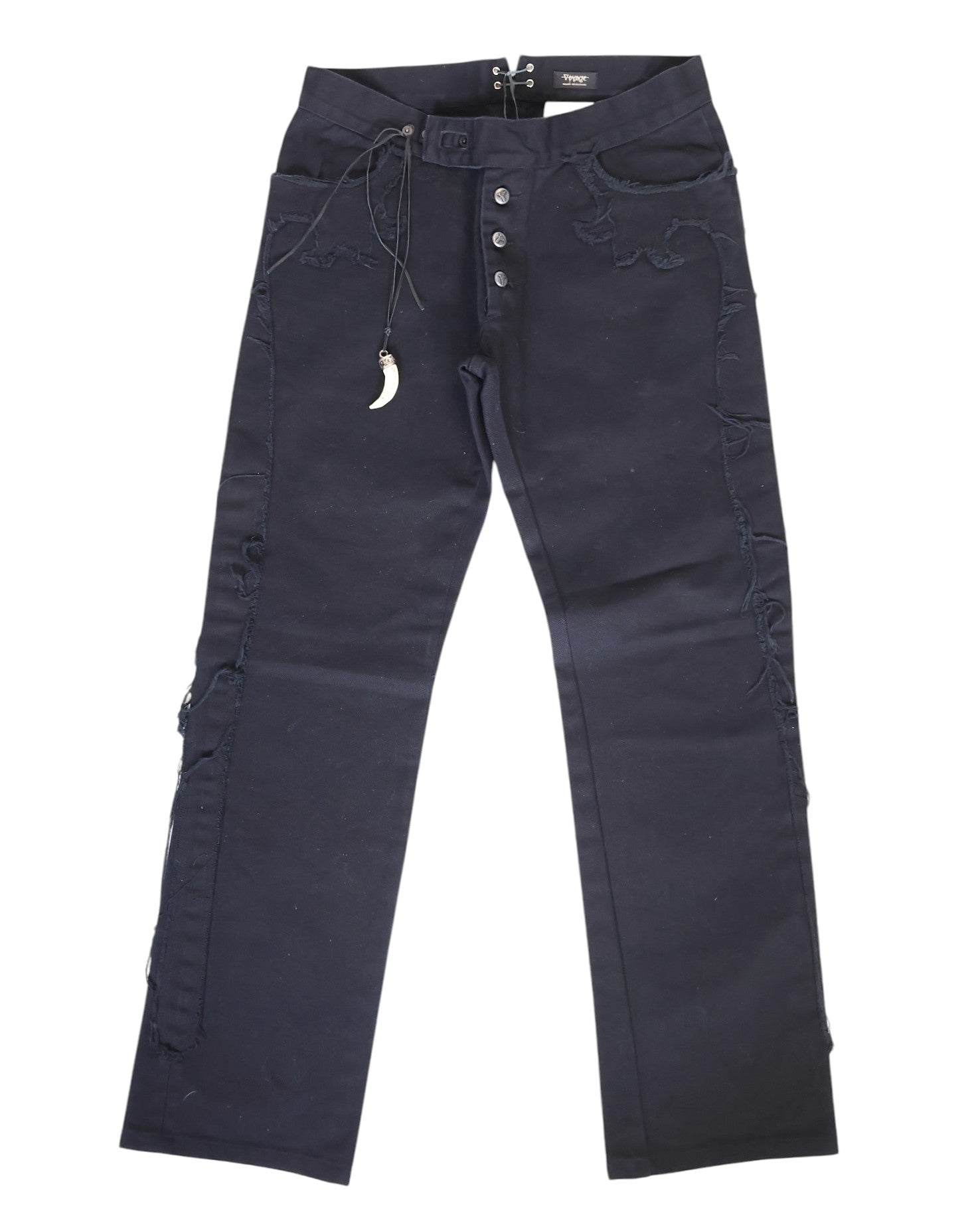 A pair of black jeans with shark teeth pendants displayed against a white background. Vintage Voyage Mazzilli Michielsens black jeans/denim trousers with straight-leg cut, visible button fly and five pockets, plus tonal stitched/appliqué trims along the seams. Finished with a waist drawcord carrying a shark-tooth–style pendant charm and back grommet lacing; luxury, rare and unique, laid flat on white.