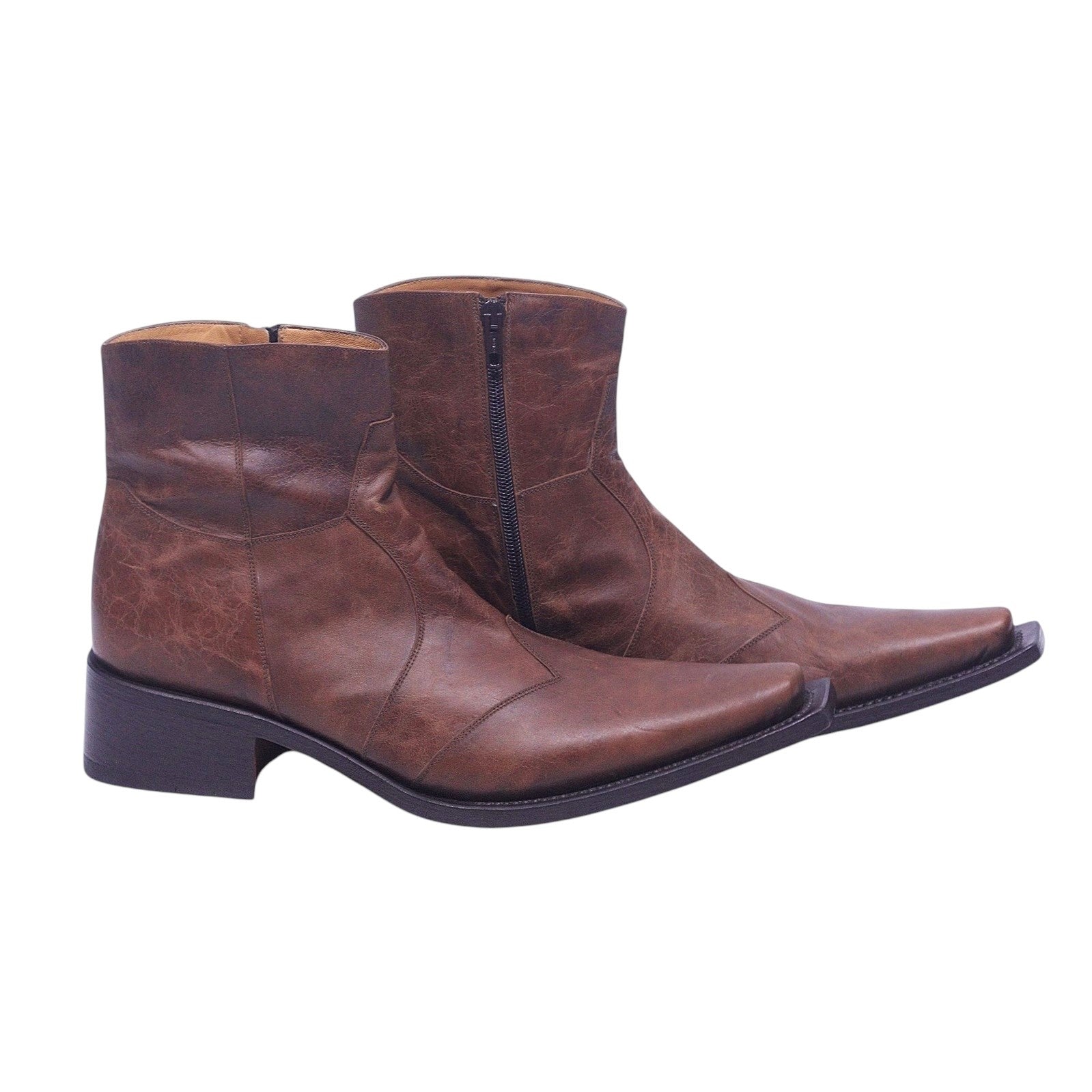 A pair of brown leather western santiag boots with a pointed toe and low heel. Vintage Gianni Barbato brown leather western “santiag” ankle boots — ultra-pointed toe cowboy boots with side zipper, stacked Cuban heel, stitched paneling, Italian designer craft (men’s/unisex).