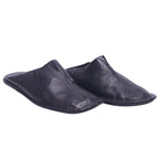 A pair of black leather slippers. Atika black leather slippers/mules in a backless, minimalist slip-on silhouette with soft grained leather, center seam and flat flexible sole; artisanal, luxury, rare and unique house shoes.