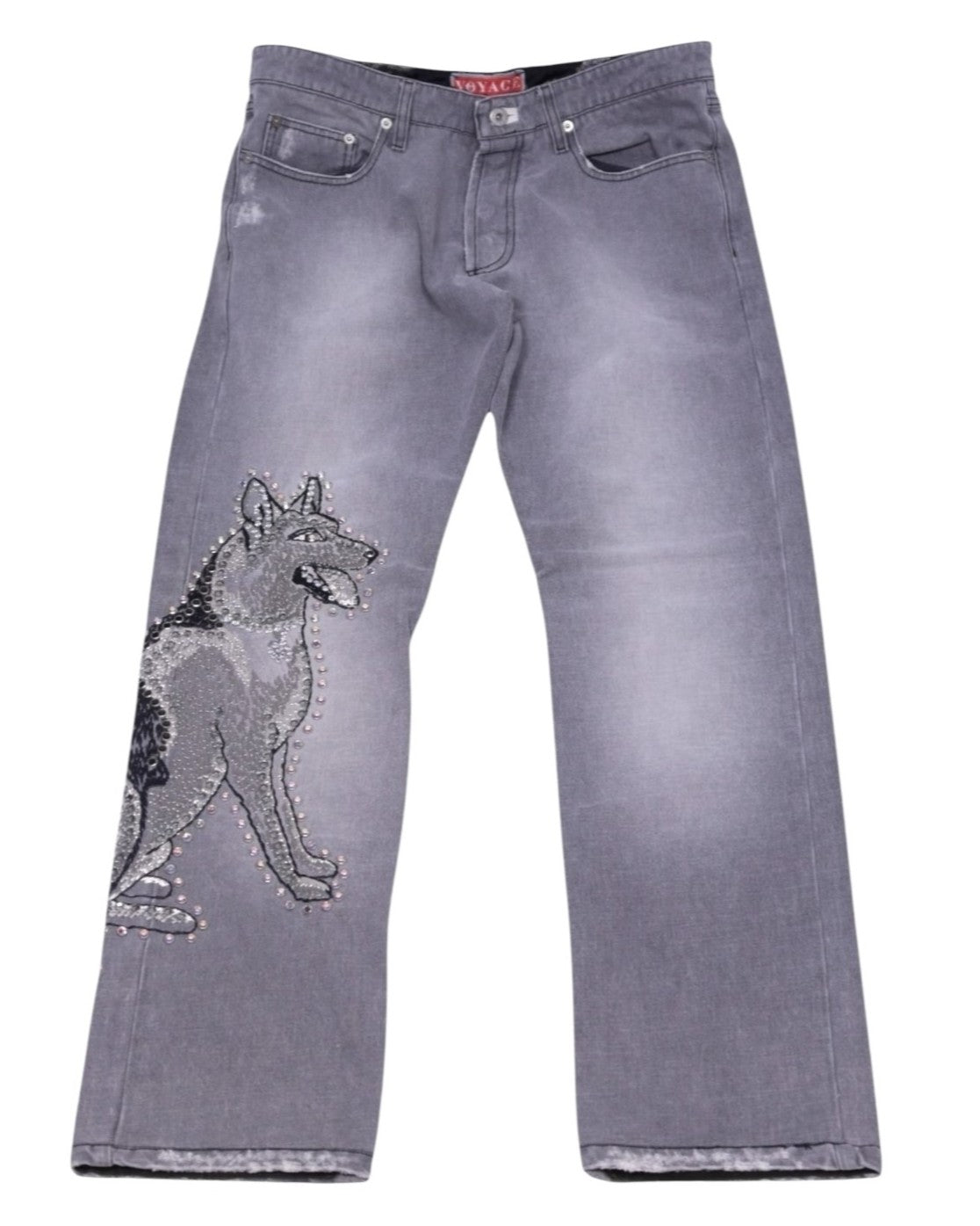 A pair of gray jeans with a wolf embroidery and rhinestones design on the left leg. Vintage Voyage Mazzilli Michielsens grey jeans/denim trousers with a large wolf embroidery and rhinestone studs down the leg; mid-rise straight-leg, five-pocket button waist with gentle fading—luxury, rare statement piece laid flat on white.