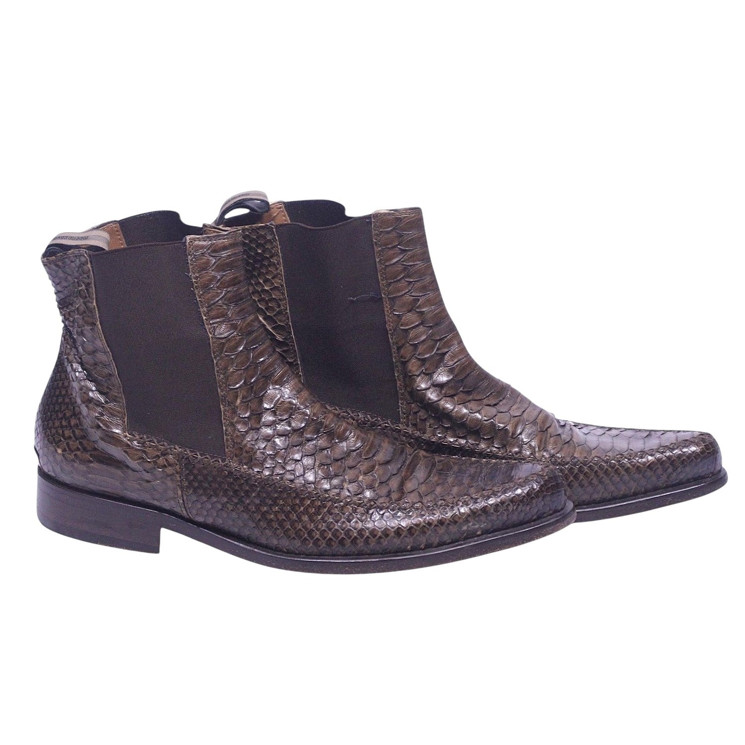 A pair of brown python leather chelsea boots with elastic side panels and a pointed toe. Roberto Cavalli brown python snakeskin Chelsea boots with elastic side panels, square-point toe, pull tabs, and low stacked heel.