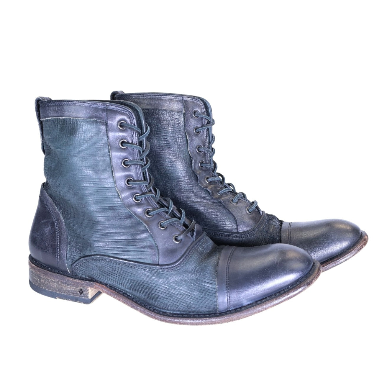 A pair of John Varvatos black leather boots with a lace-up closure, displayed against a white background. John Varvatos men’s black leather lace-up ankle boots with cap toe, textured side panels, stitched welt and stacked heel.