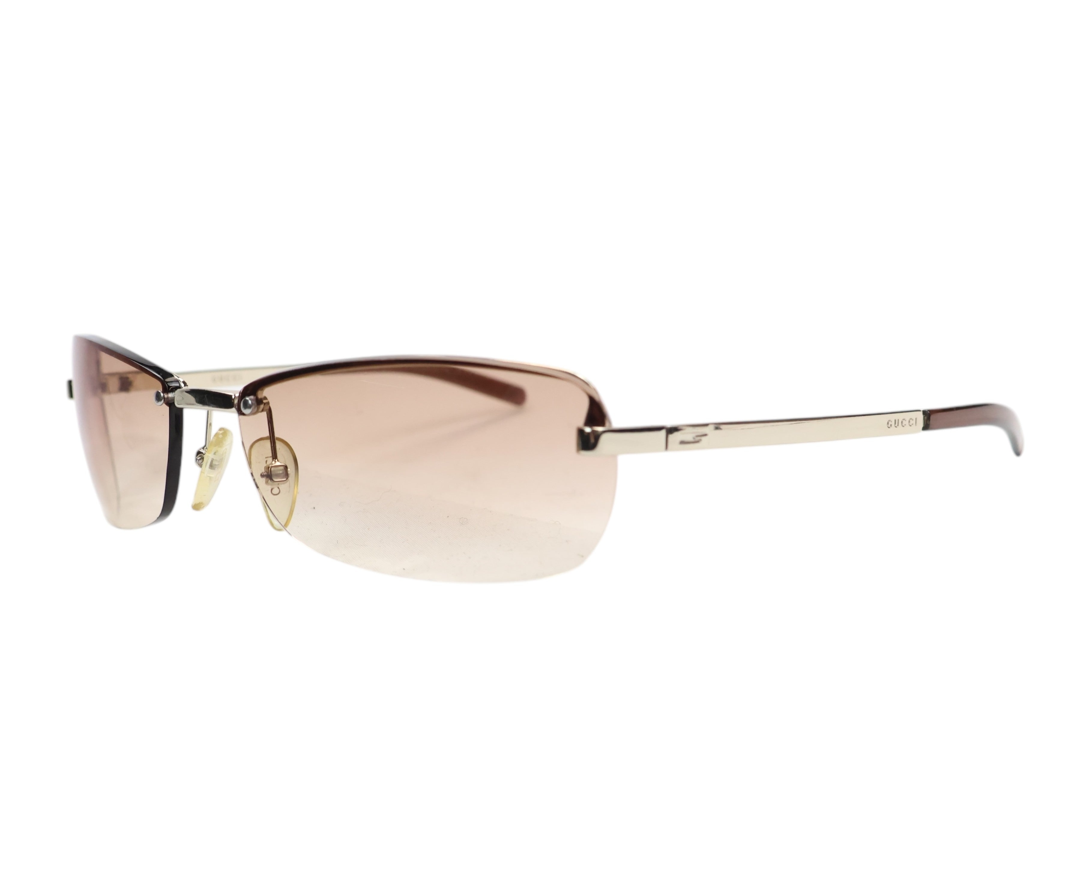 A pair of Gucci sunglasses with a metallic frame and pink gradient lenses. Gucci 1793/S sunglasses / shades; brown gradient rimless–semi-rimless rectangular wrap lenses, gold-tone metal temples with GUCCI logo; adjustable nose pads, lightweight UV protection; unisex fit for tailoring, casual or streetwear/Y2K looks; Italian luxury heritage house craftsmanship, often made in Italy; rare model, chic everyday eyewear.
