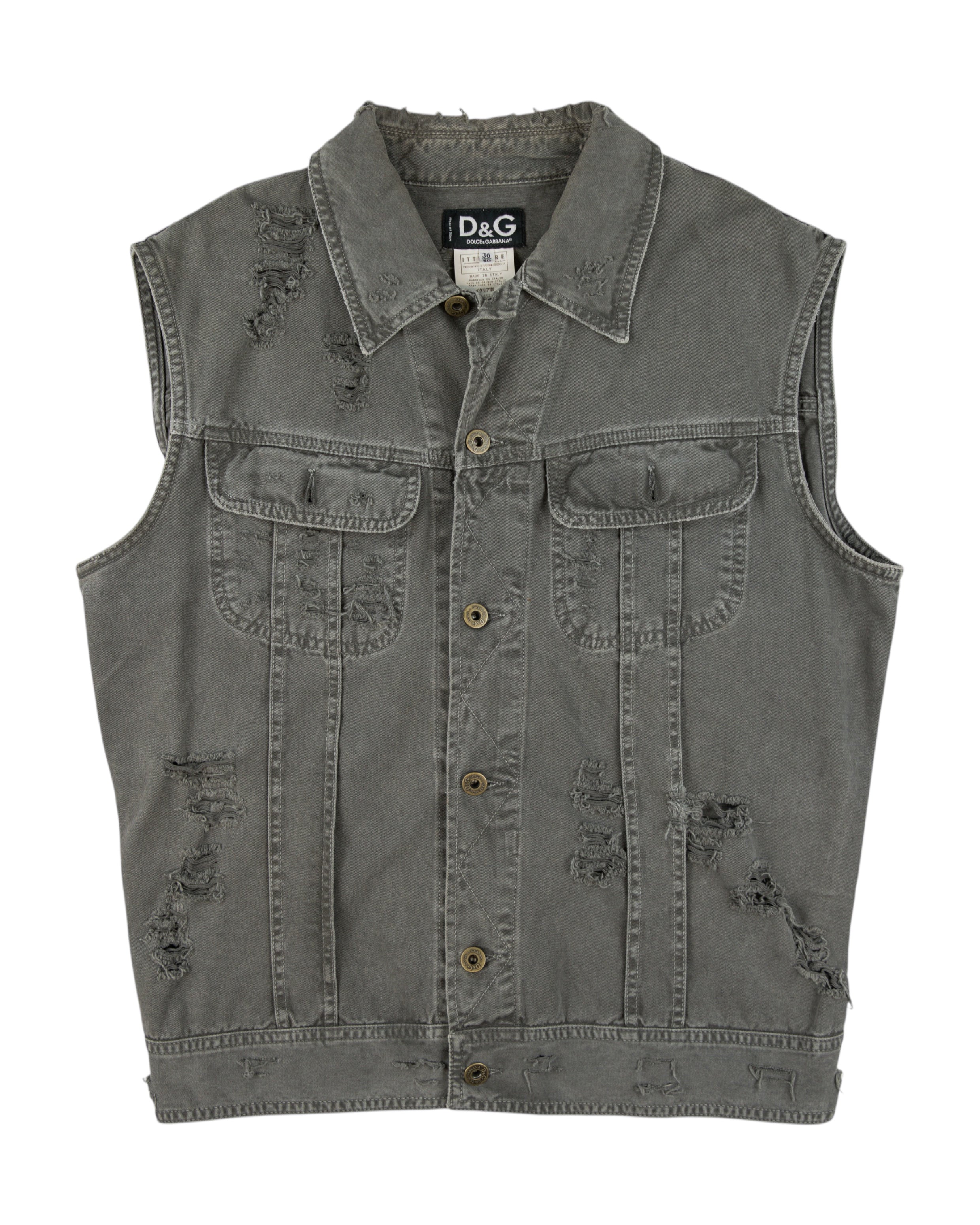Dolce & Gabbana (D&G) grey denim vest / sleeveless trucker jacket—stonewashed cotton jean fabric, distressed/ripped details, button-front placket, flap chest pockets, raw edges; grunge/workwear street style layer for tees or hoodies; unisex fit. Italian luxury label from Milan known for sharp tailoring and artisanal finishes.
