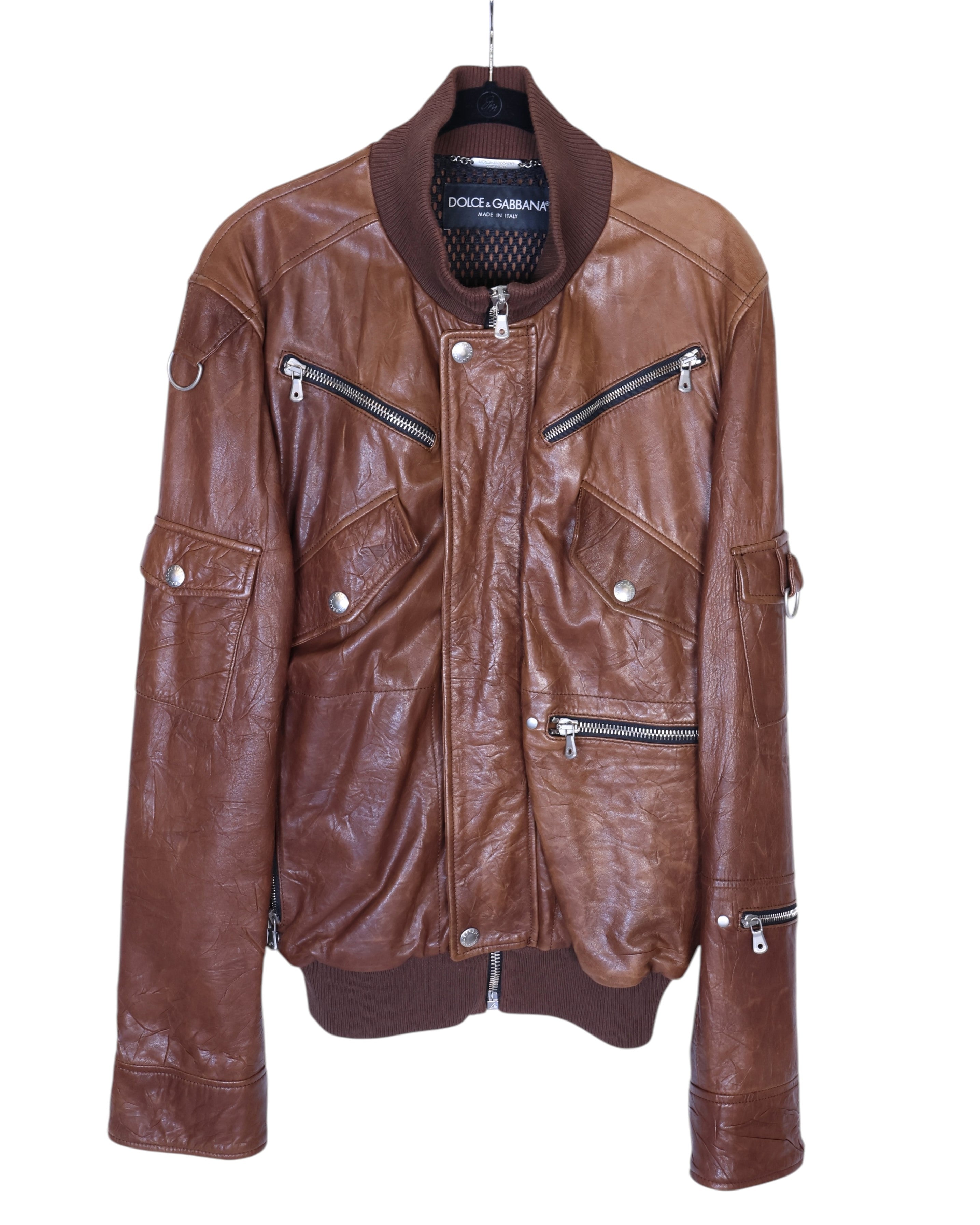 Dolce & Gabbana brown sheepskin leather bomber jacket / flight-aviator moto biker—Italian luxury craftsmanship from Milan; supple leather, ribbed stand collar/cuffs/hem, asymmetric snap-zip front, multiple zip & flap pockets, sleeve pocket and D-ring hardware, silver-tone zips, lived-in patina; tailored regular fit; unisex statement layer for jeans or tailoring.