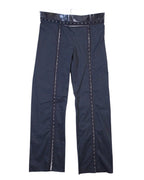 Vintage Denis Gagnon navy pinstripe trousers/pants in suiting fabric with a glossy patent-style waistband and double buttons, straight-leg cut. Front vertical trim panels with contrast ladder stitching add avant-garde tailoring; rare luxury piece laid flat on white. Quebec vintage fashion, Montreal vintage clothing