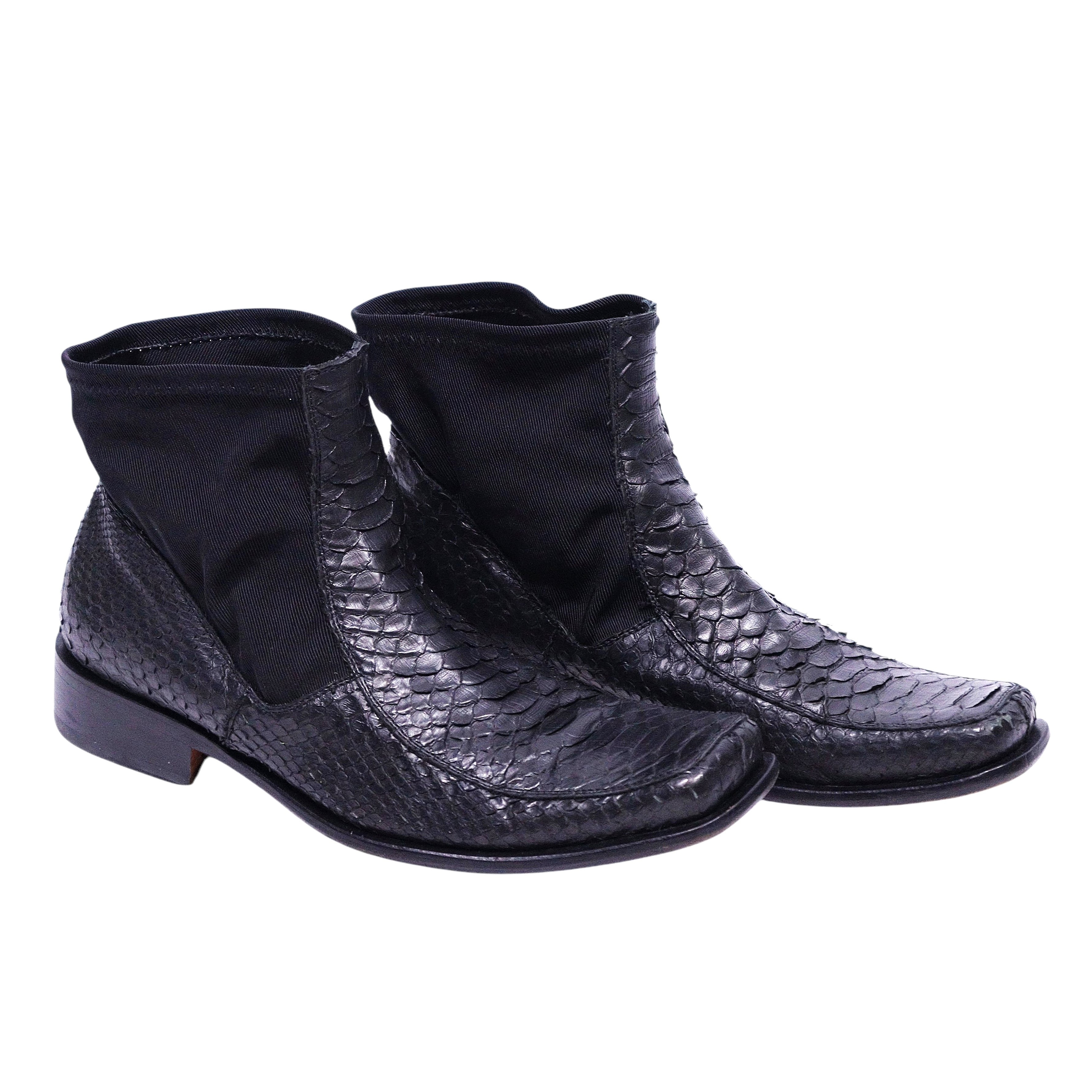 A pair of black python leather chelsea boots by Roberto Cavalli. Roberto Cavalli black snake-textured leather Chelsea boots with elastic side panels, square apron toe and low stacked heel; reptile-scale finish, vintage designer, rare.
