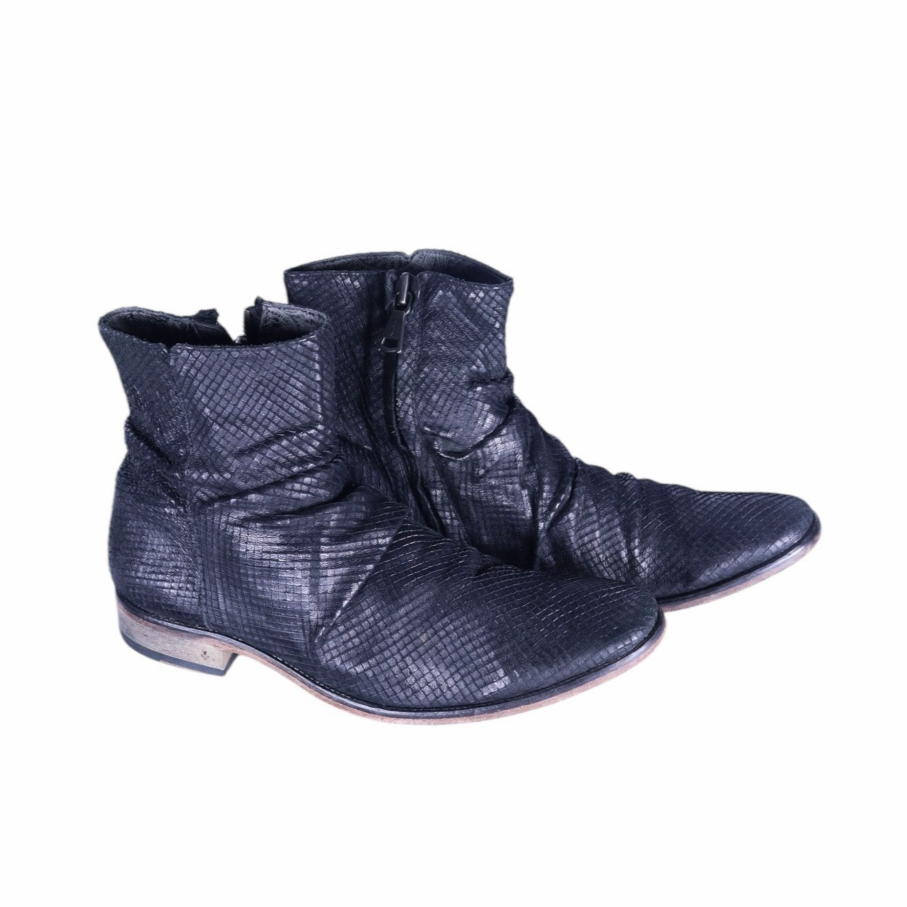 A pair of black, full-grain sheep leather boots with a geometric pattern, hand made in Italy. John Varvatos Morrison Sharpei black leather ankle boots with reptile-embossed texture, ruched shaft, side zipper, almond toe, and low stacked heel.