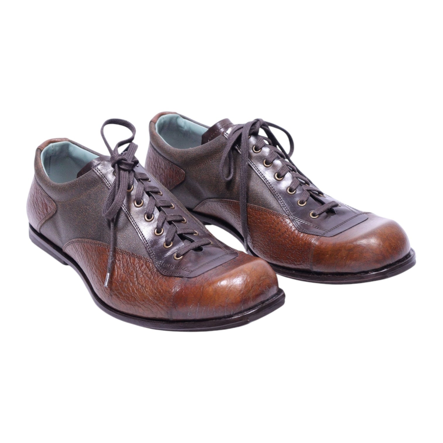 A pair of brown leather dress shoes with a lace-up closure. Kenzo men’s two-tone brown leather lace-up dress shoes with textured grain panels, round toe, and durable sole.