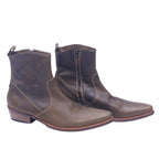 A pair of olive brown leather boots with a pointed toe and visible stitching, displayed against a white background. Roberto Cavalli olive-brown leather western santiag boots with side zipper, contrast stitching, pointed toe, pull tab, and low stacked heel.