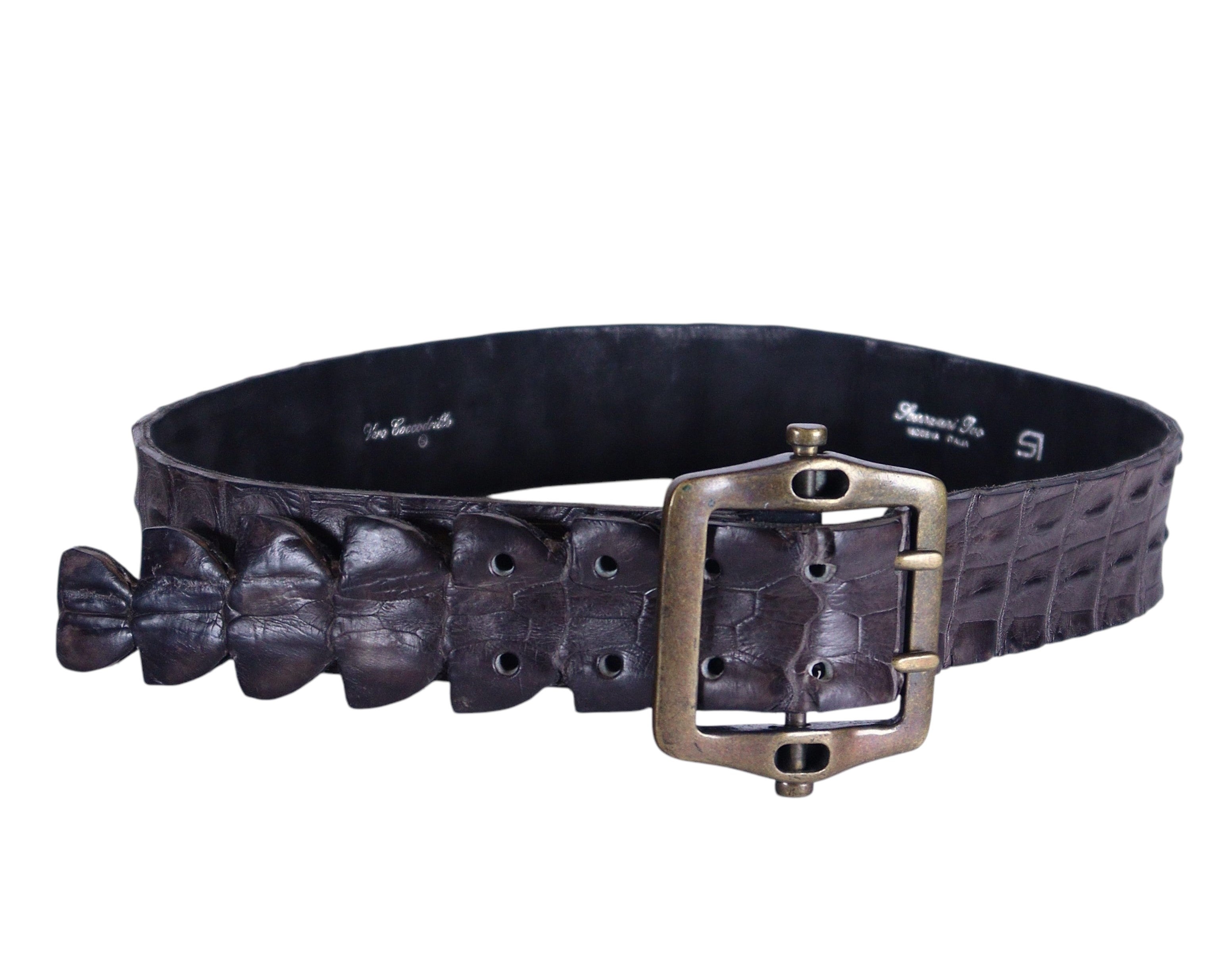 A brown crocodile leather belt with a metal buckle. Artisanal dark brown/espresso real crocodile leather belt; genuine exotic croc skin with raised scales and dorsal ridge, wide strap; antique-brass square buckle, single-prong hardware; adjustable unisex fit; great with jeans, tailoring, western looks; style tags: luxury, rock, statement, rare; heritage handmade craft, limited piece.