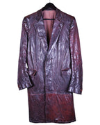 A long leather burgundy coat with a notched lapel, chest pockets, and a hem reaching at least knee-length. Carol Christian Poell burgundy/oxblood maroon leather long coat; notched lapels, single-breasted button closure, flap pockets, paneled build, wrinkled/object-dyed patina; longline overcoat fit, unisex; great over tailoring, denim, boots; style tags: avant-garde, artisanal, runway, archive, minimal; season AW04/05; brand context: Italian luxury atelier by Austrian-born designer, experimental small-batch