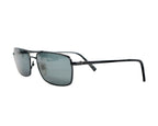 A pair of John Varavatos sunglasses with a metal frame and dark lenses. John Varvatos V116 sunglasses in gunmetal/black metal; slim rectangular/navigator frame with smoke-grey lenses, etched temples, saddle bridge and adjustable nose pads; lightweight UV-shielding eyewear; unisex; pairs with leather jackets, denim, tailoring; tags: rock, indie, minimalist, retro; brand context: American luxury label with rock-and-roll heritage; vintage/limited.
