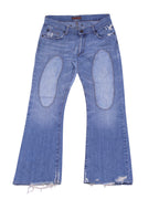 Vintage Bray Steve Alan blue denim jeans/jean trousers in a medium faded wash, mid-rise bootcut/flare silhouette with whiskering, oval knee patches, five-pocket design and button front; distressed raw/frayed hems for a worn-in look. Luxury designer piece, rare and unique, laid flat on white.