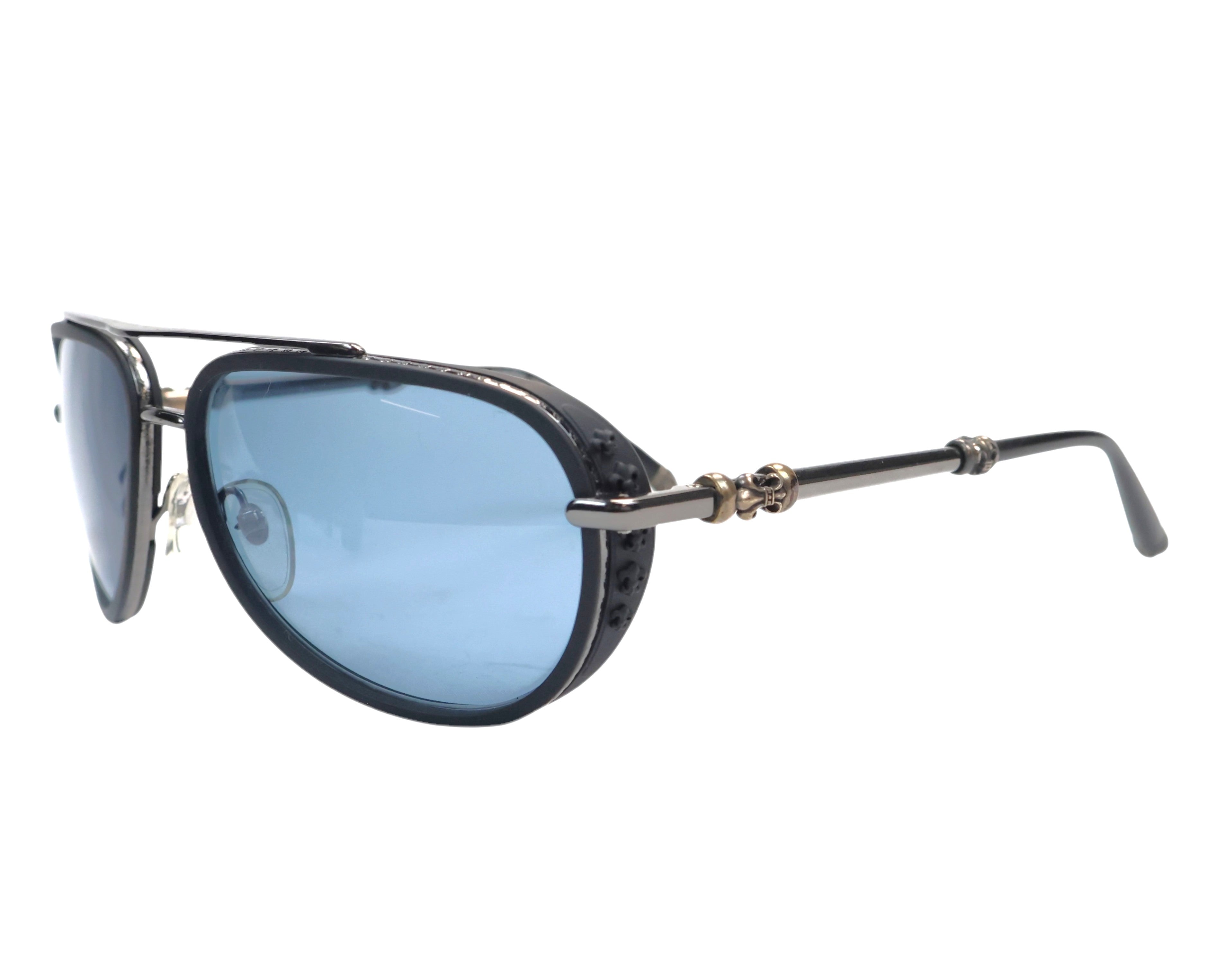 A pair of Chrome Hearts Jack Wacker II sunglasses featuring blue lenses and a patterned frame. Chrome Hearts Jack Wacker II aviator sunglasses, black/gunmetal designer shades with blue lenses, sterling-silver gothic cross hardware and leather-textured rim; American luxury brand with rock-n-roll edge, eyewear handcrafted in Japan; unisex premium eyewear, pilot frame, double-bridge style.