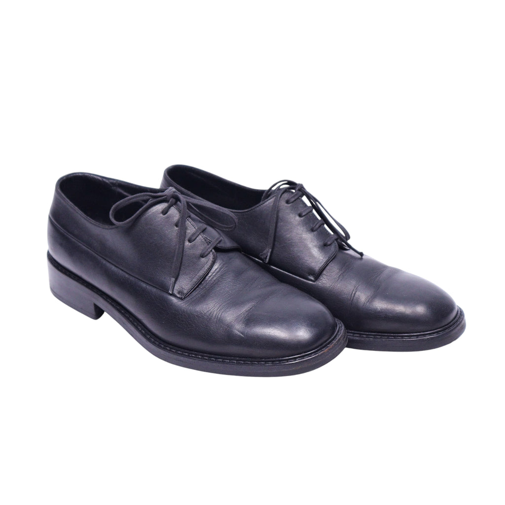 A pair of Christian Dior black leather shoes with lace-up closure. Vintage Christian Dior black leather derby/oxford shoes with smooth finish, round toe and open lacing. Minimalist dress lace-ups with stacked sole and neat stitching; luxury, rare piece.