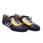 A pair of Dolce Gabbana black and yellow sneakers with laces. Vintage Dolce & Gabbana low-top lace-up sneakers in black with yellow and taupe panels; mixed-material upper with contrast stripes, rounded toe, and retro racing/bowling vibe—designer, rare.