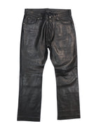 Black lambskin pants with a front zipper and button closure, regular fit, displayed on a white background. Vintage Vent Couvert black lambskin leather pants/trousers with a smooth finish; mid-rise straight-leg, five-pocket jeans style with belt loops, button front and subtle knee seams. Luxury, rare and unique piece, laid flat on white.