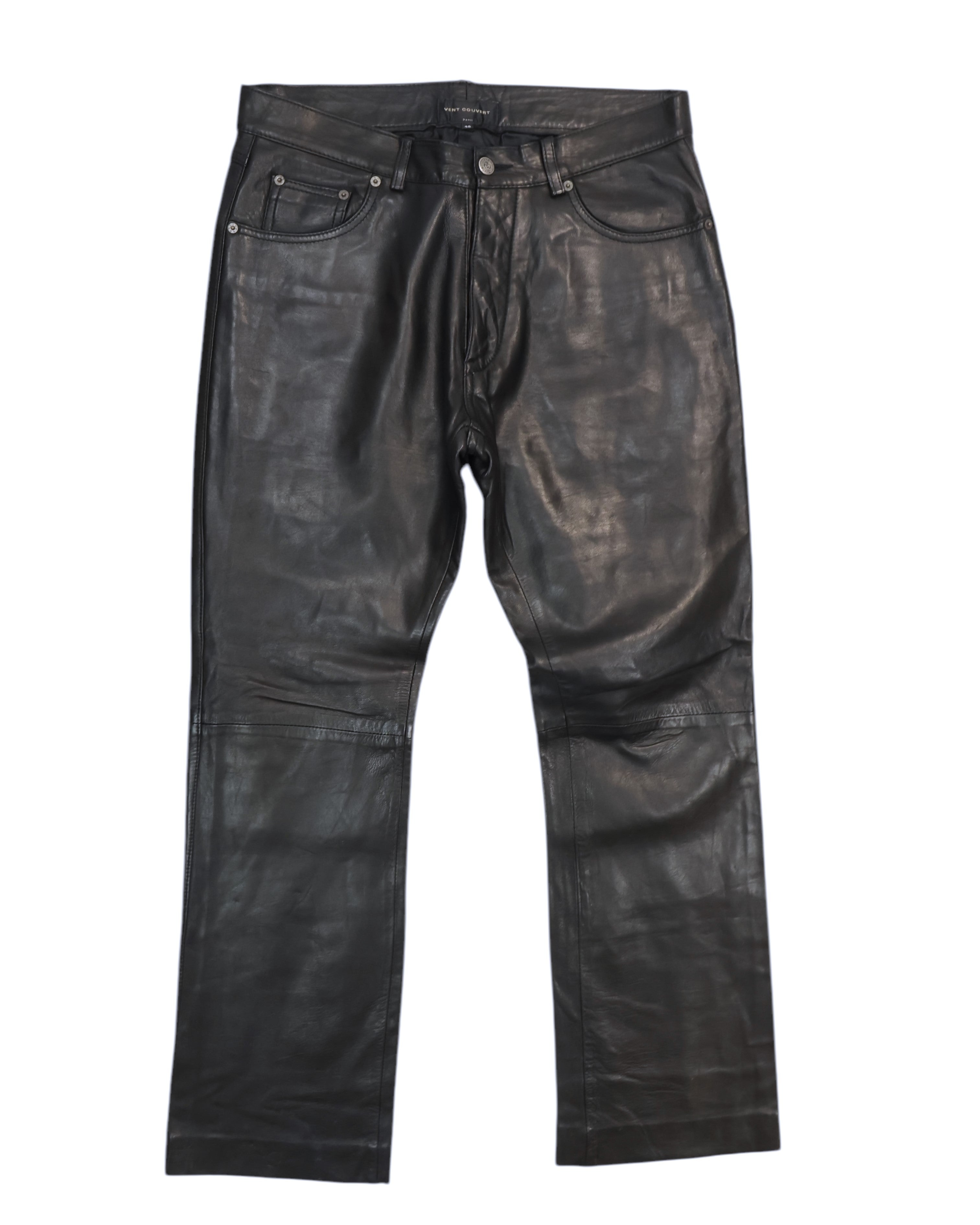 Black lambskin pants with a front zipper and button closure, regular fit, displayed on a white background. Vintage Vent Couvert black lambskin leather pants/trousers with a smooth finish; mid-rise straight-leg, five-pocket jeans style with belt loops, button front and subtle knee seams. Luxury, rare and unique piece, laid flat on white.