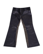 A pair of Roberto Cavalli leather pants with a solid pattern, featuring a blend of dark hues and metallic elements. Two-tone black and dark taupe leather pants with flared legs and inset contrast panels; jean-style waistband with belt loops, fly and small ankle slits. Vintage designer pair, rare and unique.