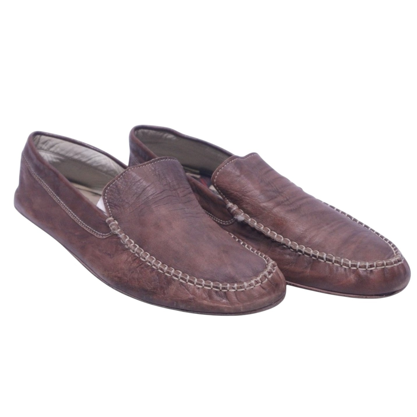 A pair of brown leather moccasin shoes for adults. Roberto Cavalli brown leather moccasin loafers with hand-stitched moc-toe apron, slip-on design, and low profile.