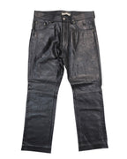 Black calfskin leather pants with a front zipper and button closure, displayed against a white background. Vent Couvert black calfskin leather pants in a straight, jean-style cut with five pockets, belt loops and zip fly. Panelled legs with horizontal seams and a subtle glossy finish; vintage, luxury, rare.
