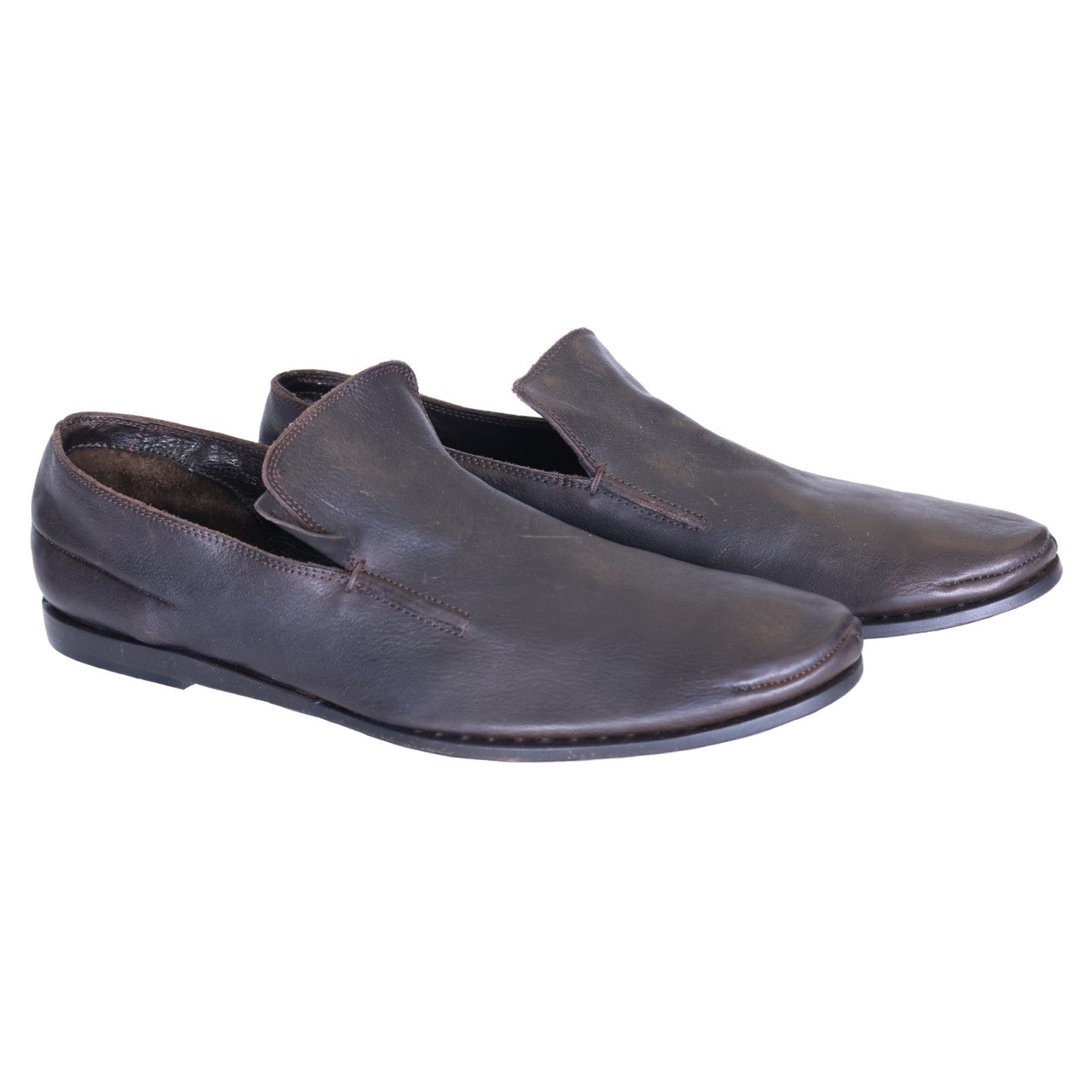 A pair of brown leather loafers on a white background. Vintage Dior brown leather loafers in a minimalist slip-on/moccasin style with rounded toe, low stacked sole, and gentle patina—refined, rare luxury.