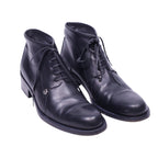 A pair of black leather boots with laces and a low heel.Gianni Versace black leather lace-up ankle boots with a clean round toe, five-eyelet closure and a low stacked heel. Smooth polished finish with a subtle logo charm; vintage, luxury, rare.