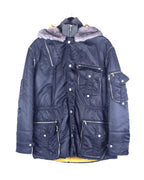 A Dolce & Gabbana black coat with rabbit fur on the hood, multiple pockets, and a zipper closure. Dolce & Gabbana navy/black nylon parka coat with rabbit-fur hood trim; insulated shell, rib-knit stand collar insert, multi cargo pockets, zip/snap front, silver-tone hardware, contrast yellow lining; regular fit, unisex; winter, streetwear, denim; style tags: utility, military, Y2K; brand context: Italian luxury house, Made in Italy craft.
