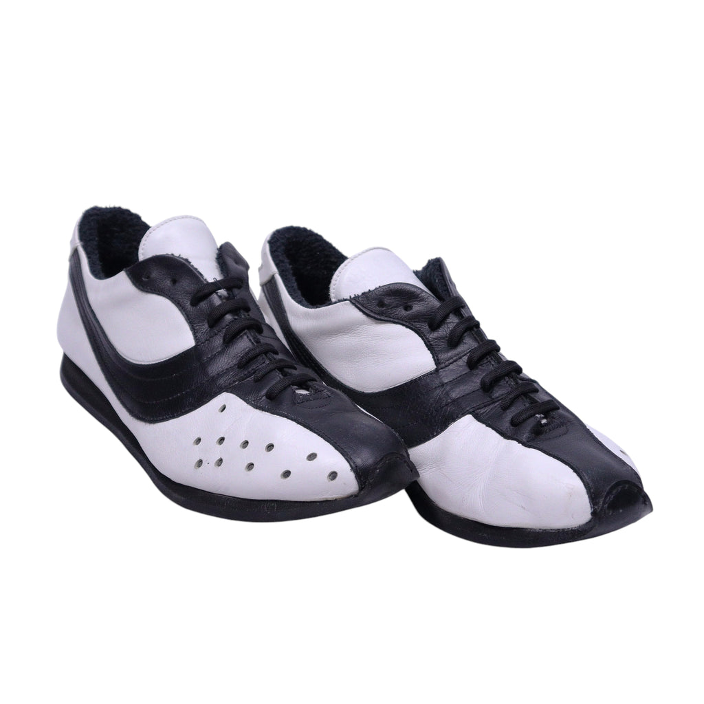 A pair of Dolce Gabbana black and white leather shoes with lace-up closure. Dolce & Gabbana low-top lace-up sneakers in black and white leather with contrast panels, perforated toe detail and a slim rubber sole. Retro racing-inspired, Italian designer pair; vintage and rare.