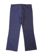 Back view of two-tone navy pants showing a split-panel design—indigo on one side, deep midnight blue on the other—with straight legs, plain waistband and smooth woven finish; refined, designer, unique.