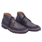 A pair of Issey Miyake brown chukka boots with lace-up closure and a rubber sole. Issey Miyake brown chukka/ankle boots in smooth leather with textured fabric trim, moc-toe apron stitching and open lacing. Thick contrast welt and lug sole; vintage designer, rare.