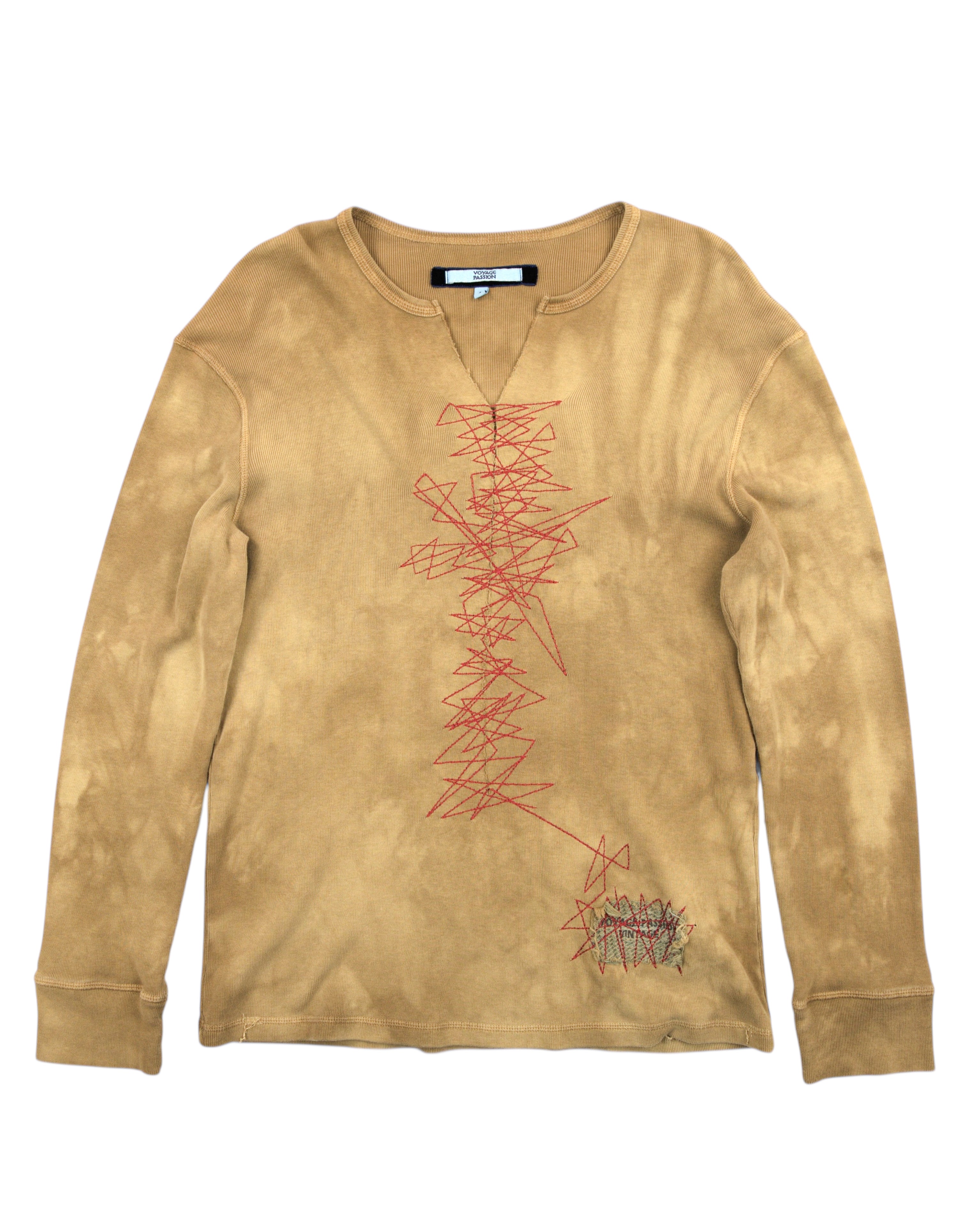 Beige long-sleeve shirt with red abstract design on a white background Vintage Voyage Passion long-sleeve T-shirt — European artisanal/cult label; ribbed cotton jersey thermal top in ochre/mustard/camel tie-dye wash; split crew neckline (notch-V), bold red zigzag embroidery down front, cuffed sleeves; soft stretch knit; streetwear/boho/avant-garde vibe; unisex fit; rare, collectible.