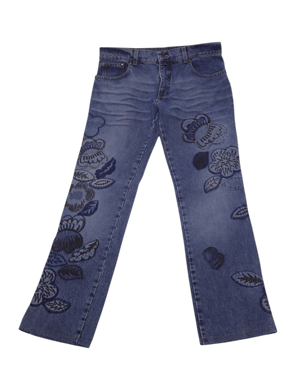 A pair of blue jeans with floral embroidery. Vintage Roberto Cavalli blue jeans/denim trousers with tonal floral embroidery/appliqué blooms on both legs, mid-rise straight-leg cut, five-pocket button waist, and gentle fading/whiskering, laid flat on white. Luxury designer piece—rare and unique. Blue straight-leg denim with tonal blooms and gentle fading