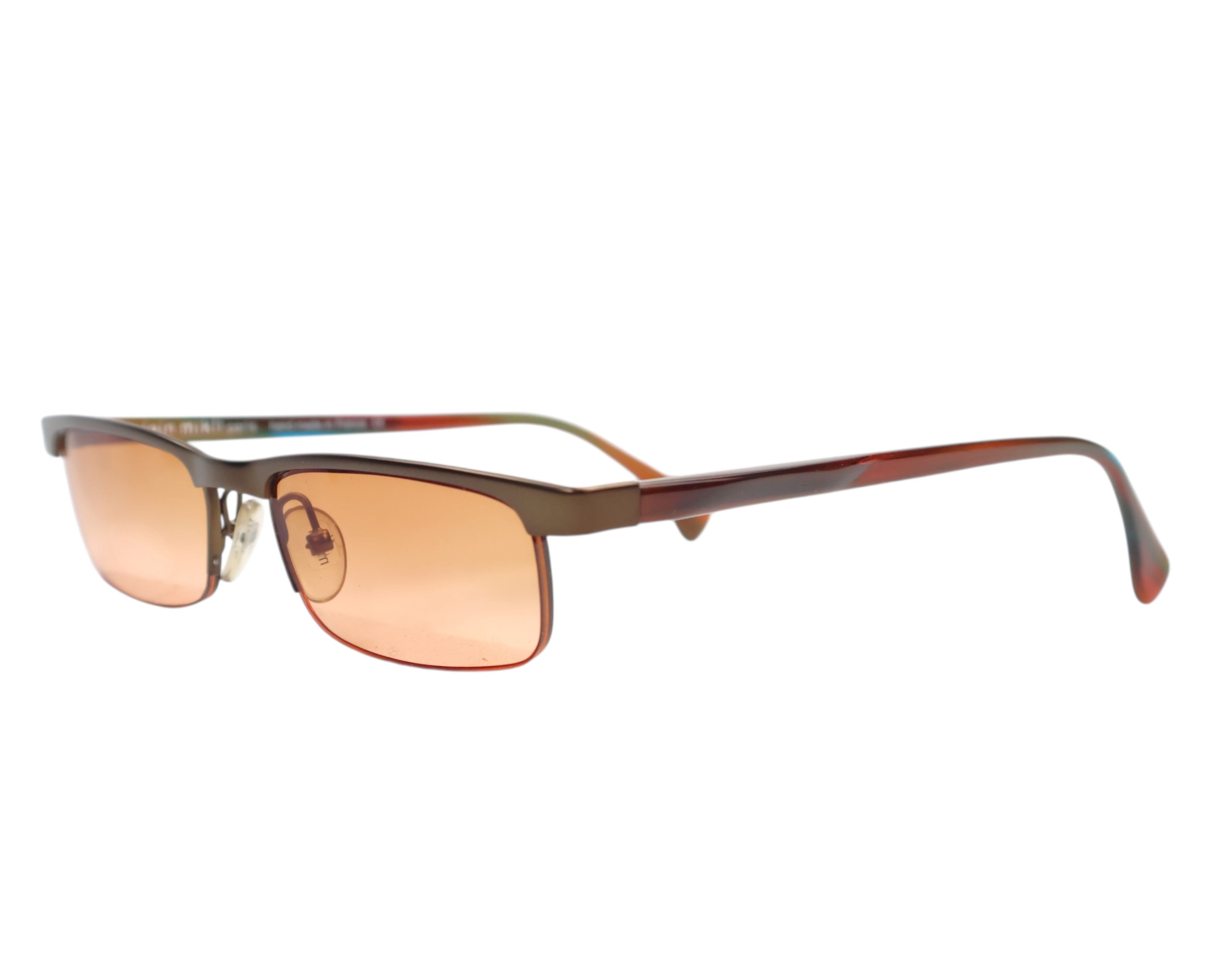 Alain Mikli Paris bronze/olive metal rectangular sunglasses; slim narrow frame with amber/orange tinted lenses; marbled red-brown acetate temples, adjustable nose pads; lightweight UV eyewear, unisex; pairs with tailoring, streetwear, driving; tags: avant-garde, Y2K, minimalist; French artisanal eyewear house, luxury, rare.