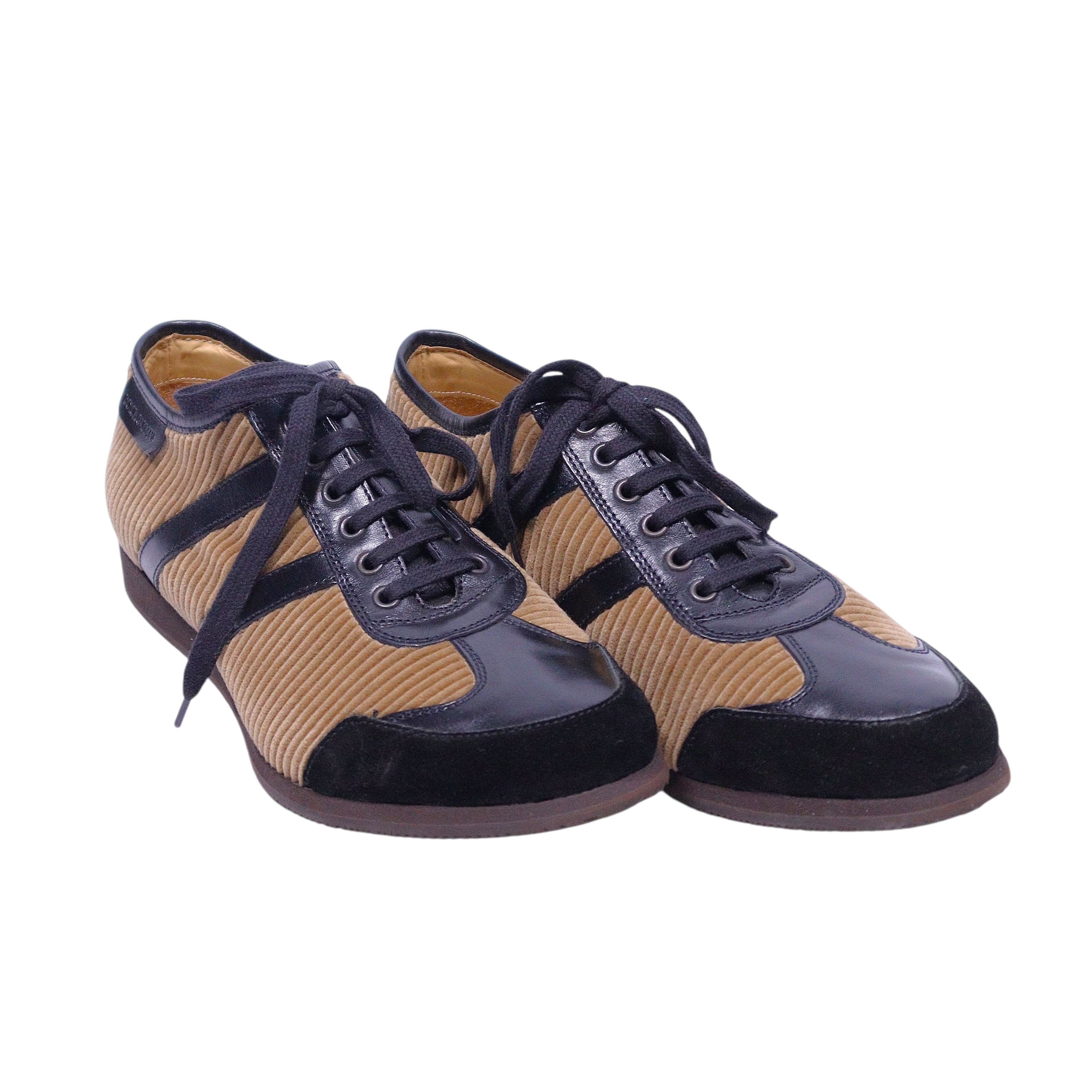 A pair of brown and beige Dolce Gabbana leather shoes with lace-up closure. Vintage Dolce & Gabbana low-top lace-up sneakers in brown and beige, featuring ribbed corduroy panels with black leather trim, rounded toe and contrast laces. Retro track-inspired designer trainers; rare and high-end.