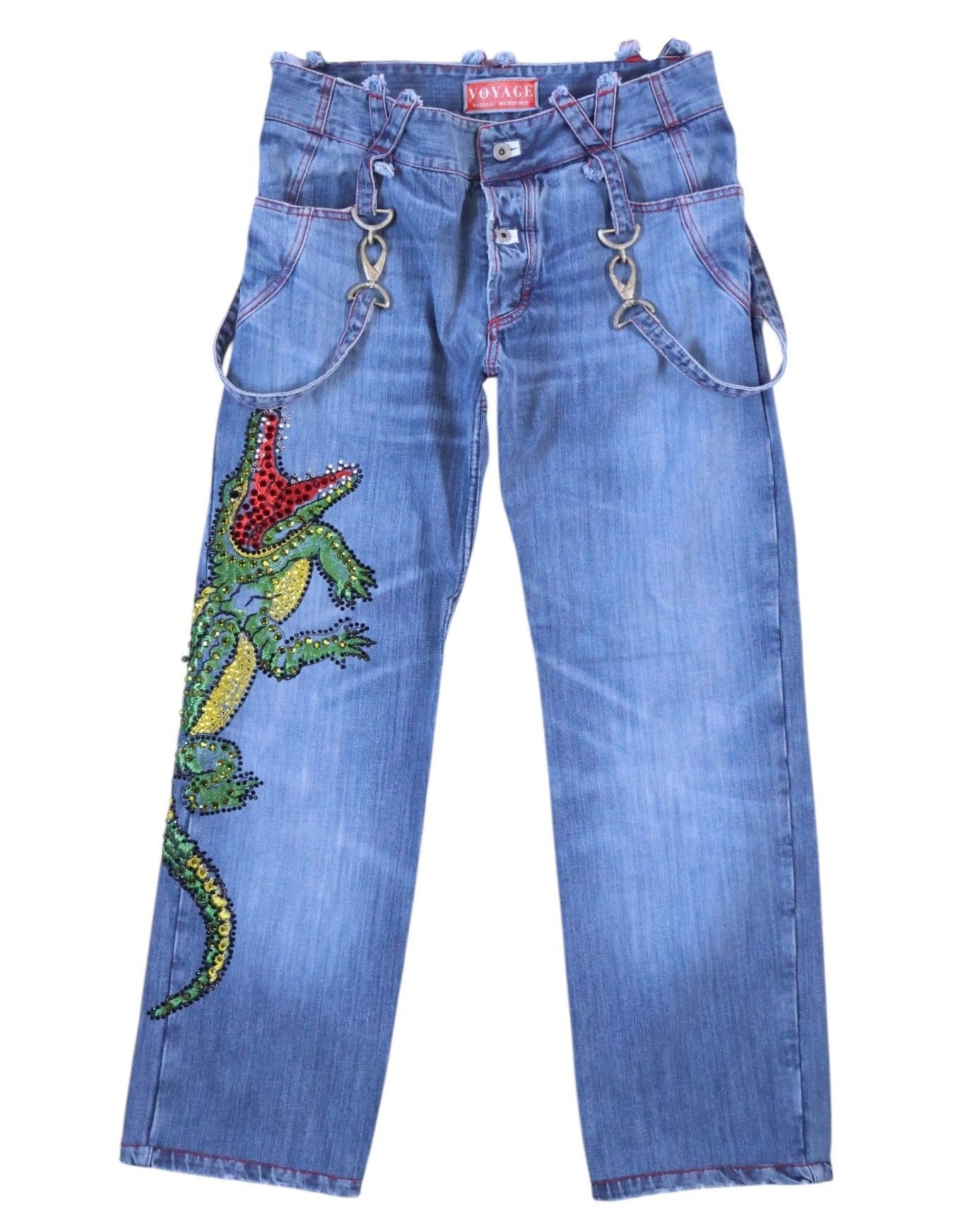 A pair of blue jeans with a crocodile pattern and rhinestone embellishments. Vintage Voyage Mazzilli Michielsens blue jeans/denim trousers with a large crystal-rhinestone crocodile/lizard motif down the leg, red contrast stitching, and a waistband with strap-and ring details. Mid-rise straight leg with classic pockets and button fly; luxury designer, rare and unique, laid flat on white.