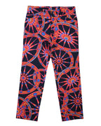 Vintage 1990s Dolce & Gabbana black trousers/pants with vivid baroque wheel–medallion graphic in red, blue and gold; slim straight leg, five-pocket style with belt loops and button front. Luxury designer statement piece, rare and unique, laid flat on white.