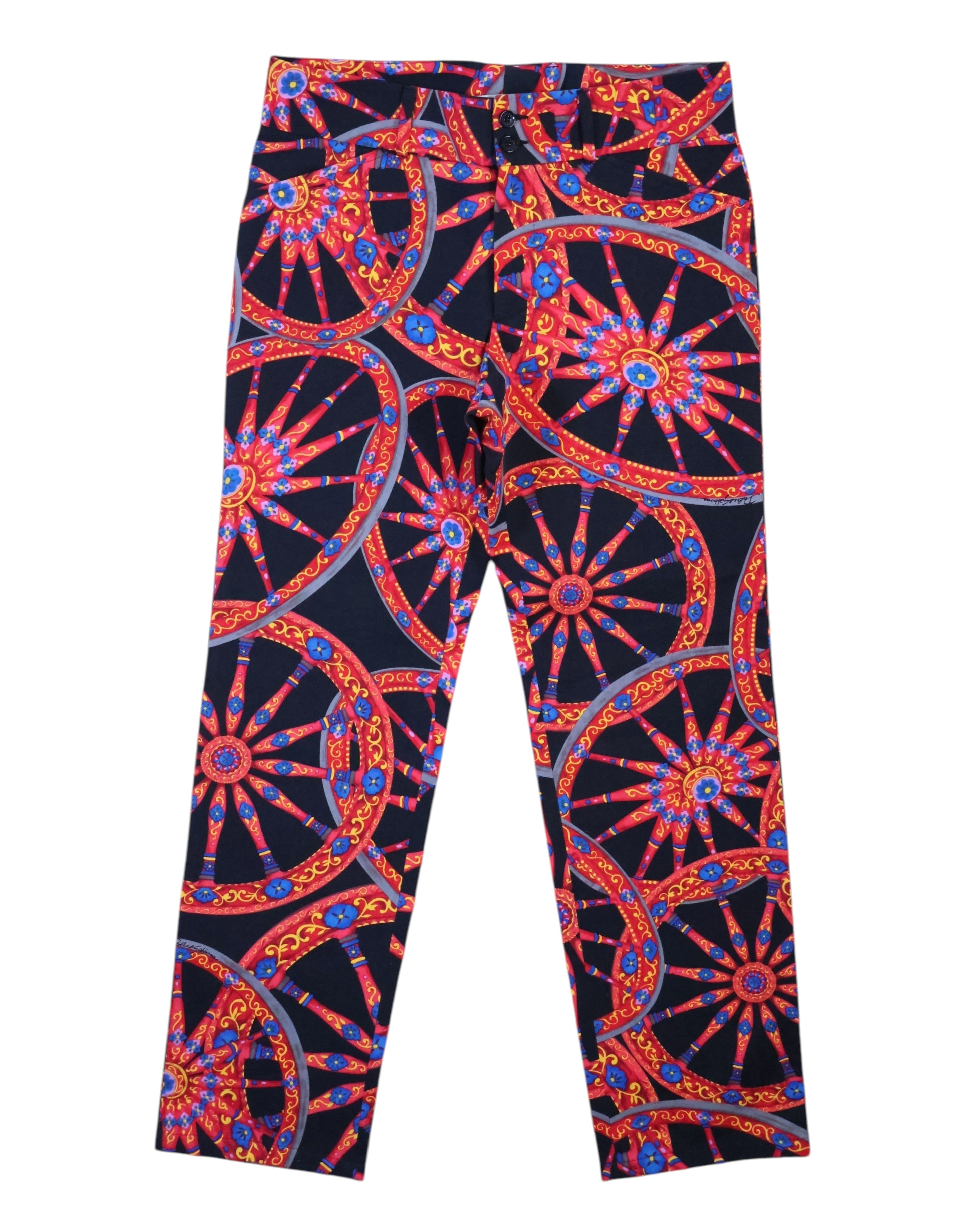 Vintage 1990s Dolce & Gabbana black trousers/pants with vivid baroque wheel–medallion graphic in red, blue and gold; slim straight leg, five-pocket style with belt loops and button front. Luxury designer statement piece, rare and unique, laid flat on white.