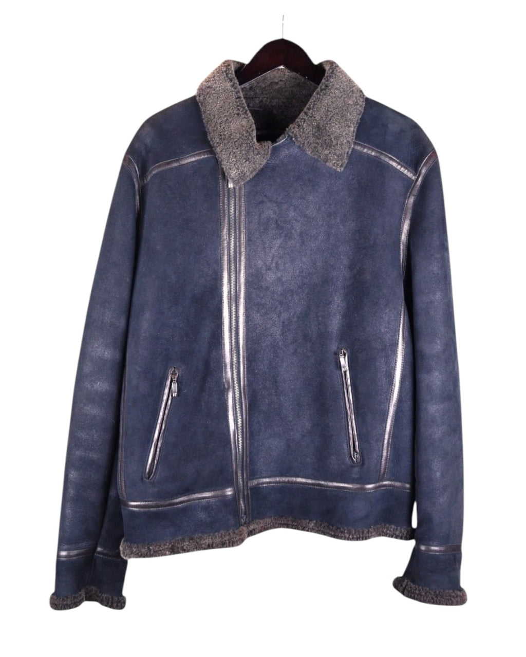 A blue leather jacket with wool lining, featuring a mandarin collar, zipper front, and multiple pockets. Bill Tornade navy/ink-blue leather shearling jacket; genuine sheepskin with plush wool lining and collar, silver-tone zips, vertical zip pockets, contrast seams; warm winter weight, boxy-relaxed fit, unisex; great with denim, boots or tailoring; tags: aviator, biker, rock, Parisian; Bill Tornade (French label, Paris menswear, rock-heritage).