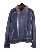 A blue leather jacket with wool lining, featuring a mandarin collar, zipper front, and multiple pockets. Bill Tornade navy/ink-blue leather shearling jacket; genuine sheepskin with plush wool lining and collar, silver-tone zips, vertical zip pockets, contrast seams; warm winter weight, boxy-relaxed fit, unisex; great with denim, boots or tailoring; tags: aviator, biker, rock, Parisian; Bill Tornade (French label, Paris menswear, rock-heritage).